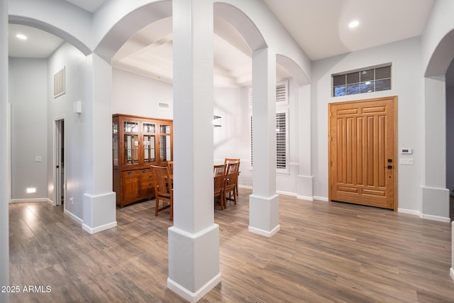 foyer entrance with a high ceiling and wood-type flooring