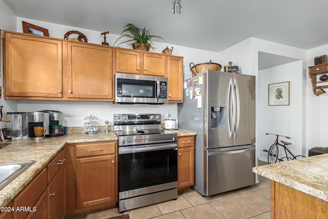 kitchen featuring stainless steel appliances and light tile patterned floors