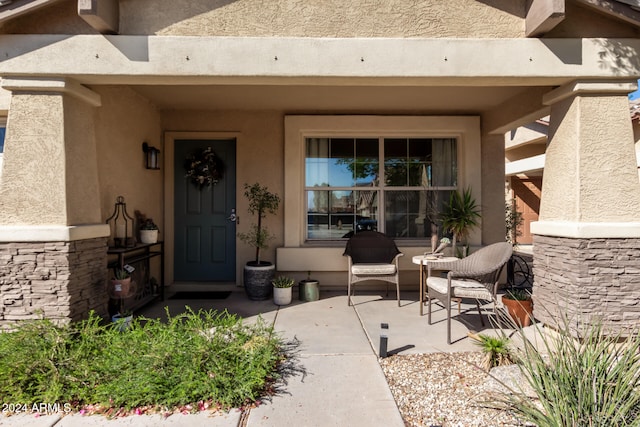 view of exterior entry with a patio area