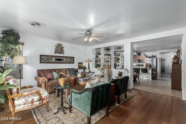 living room featuring ceiling fan and dark hardwood / wood-style flooring