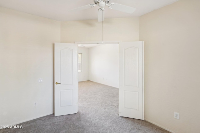 unfurnished room featuring ceiling fan and carpet