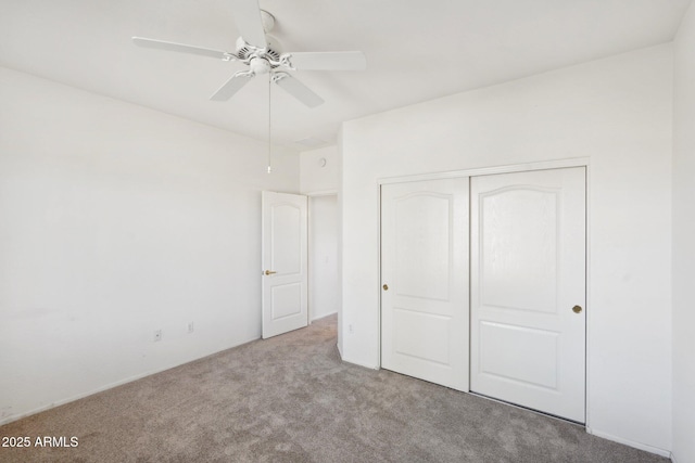 unfurnished bedroom featuring light carpet, a closet, and ceiling fan