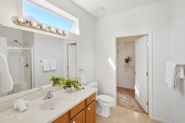 bathroom with vanity, a shower with shower door, and toilet