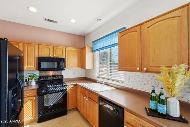 kitchen featuring black appliances, backsplash, and sink