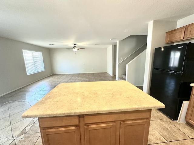 23284 W Pima St, Buckeye, AZ 85326 - kitchen featuring freestanding refrigerator, light tile patterned flooring, a kitchen island, a ceiling fan, and open floor plan