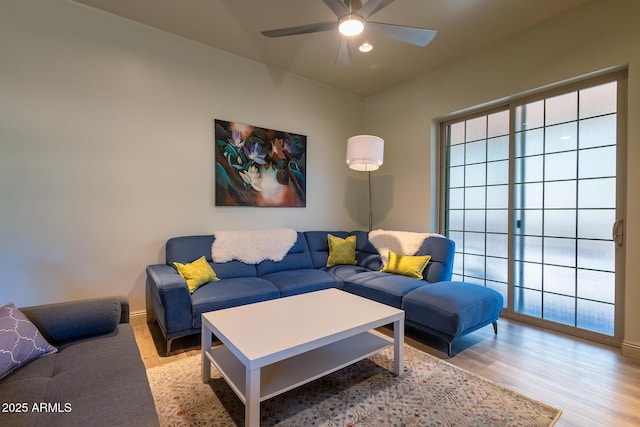 living area with a healthy amount of sunlight, baseboards, a ceiling fan, and wood finished floors
