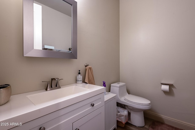half bath featuring vanity and toilet