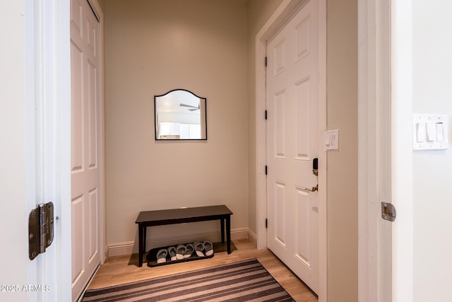 doorway with baseboards and light wood finished floors