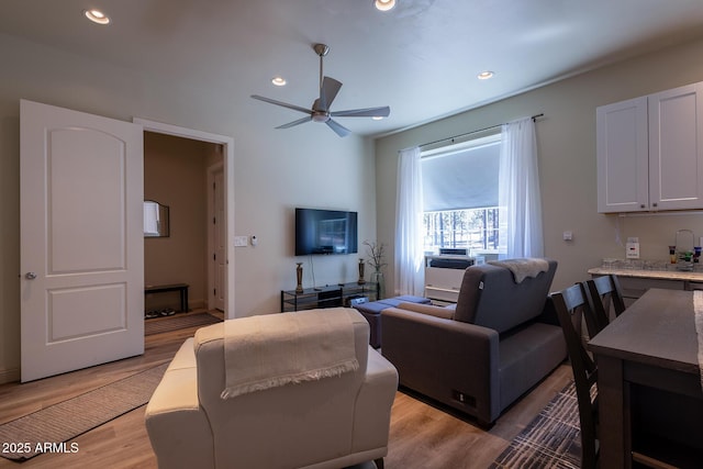 living area with recessed lighting, light wood-type flooring, and a ceiling fan