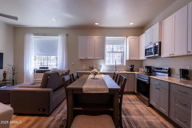 kitchen with stainless steel appliances, gray cabinetry, open shelves, and recessed lighting