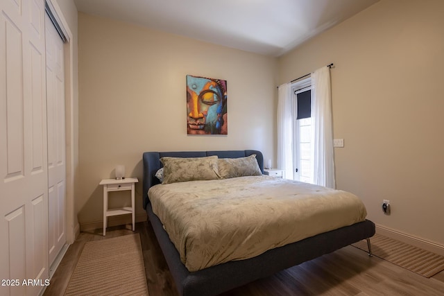 bedroom with a closet, baseboards, and wood finished floors