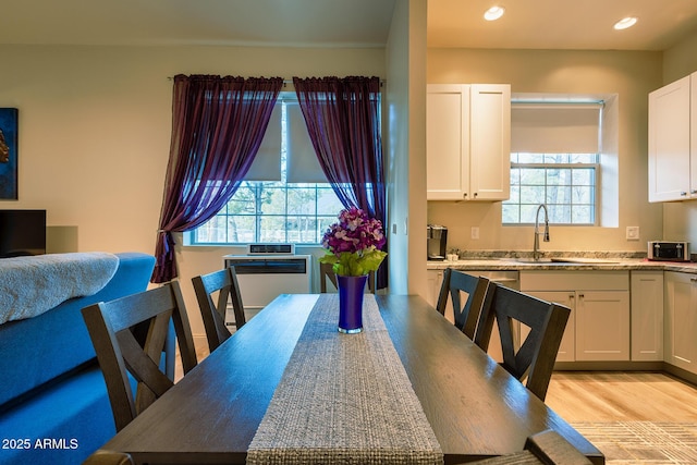 dining area with light wood finished floors and recessed lighting