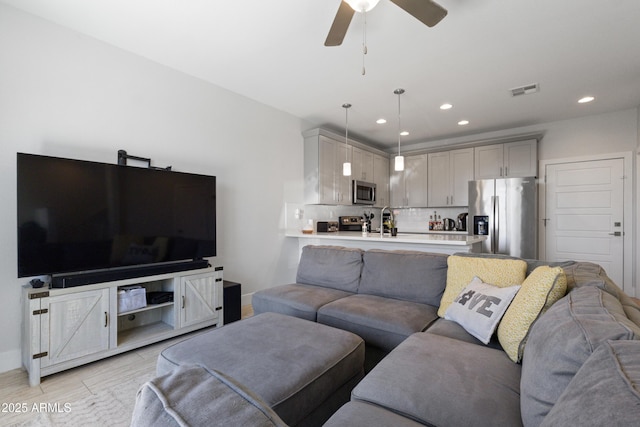 living area with light wood-style floors, recessed lighting, a ceiling fan, baseboards, and visible vents