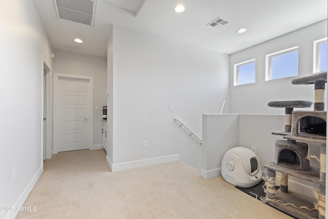 interior space featuring light colored carpet, recessed lighting, and visible vents