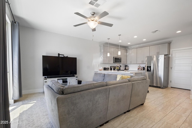 living room with a ceiling fan, recessed lighting, and visible vents