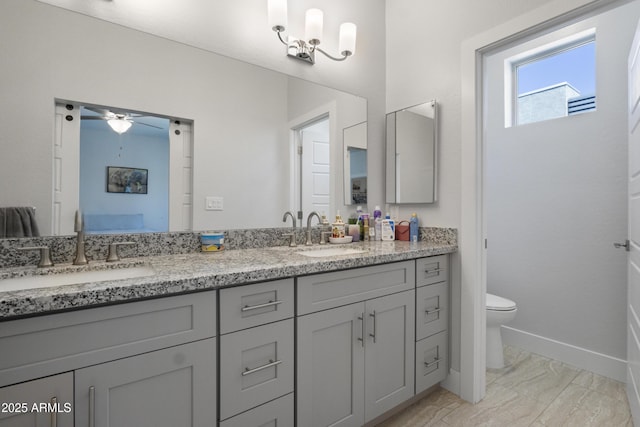 full bathroom with a sink, marble finish floor, ceiling fan, and toilet