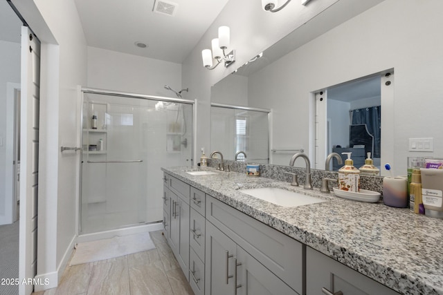 full bath with double vanity, visible vents, a sink, and a stall shower