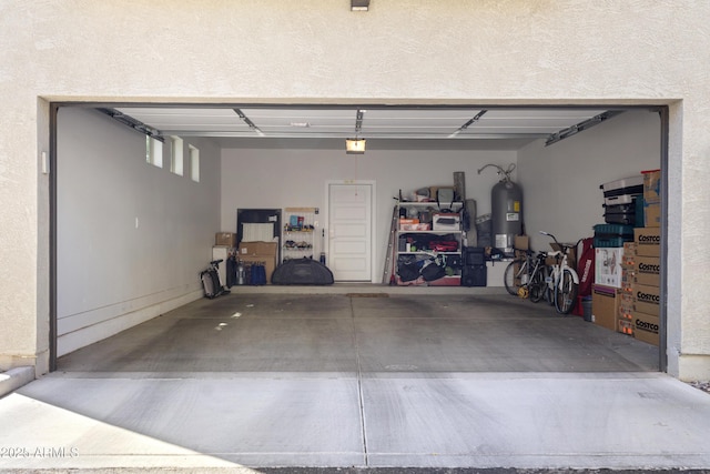 garage with a garage door opener and electric water heater