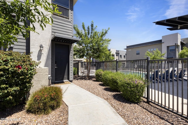 property entrance with fence and stucco siding