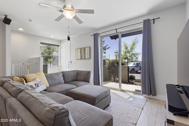 living area with baseboards, light wood-type flooring, a ceiling fan, and recessed lighting