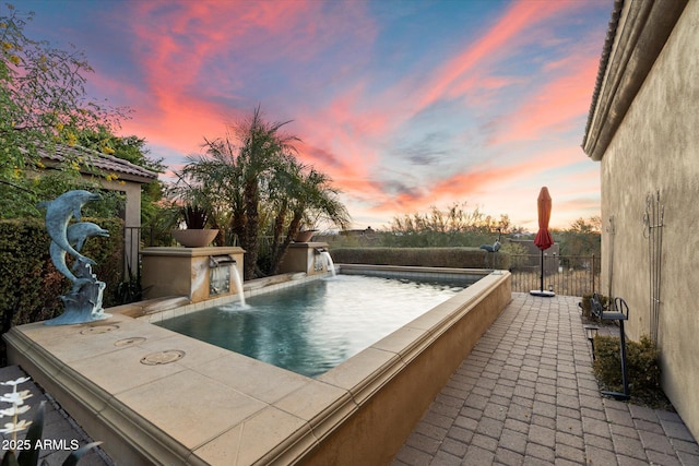 pool at dusk with pool water feature