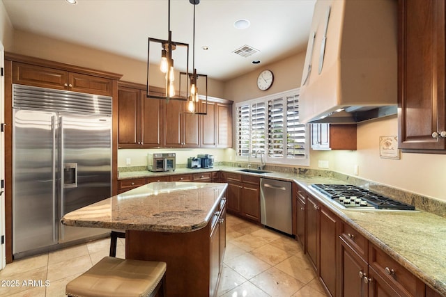 kitchen featuring a center island, stainless steel appliances, a kitchen breakfast bar, sink, and custom range hood