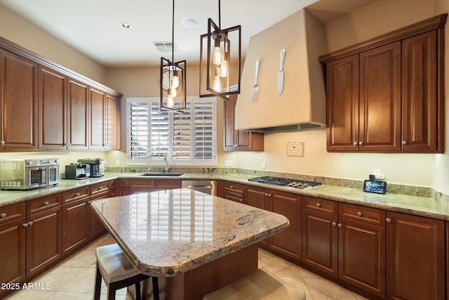 kitchen featuring appliances with stainless steel finishes, sink, light tile patterned floors, a kitchen bar, and a center island