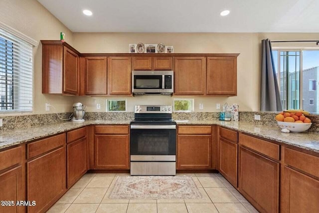 2150 W Alameda Rd Unit 1313, Phoenix, AZ 85085 - kitchen with stainless steel appliances, brown cabinets, light stone counters, light tile patterned floors, and recessed lighting