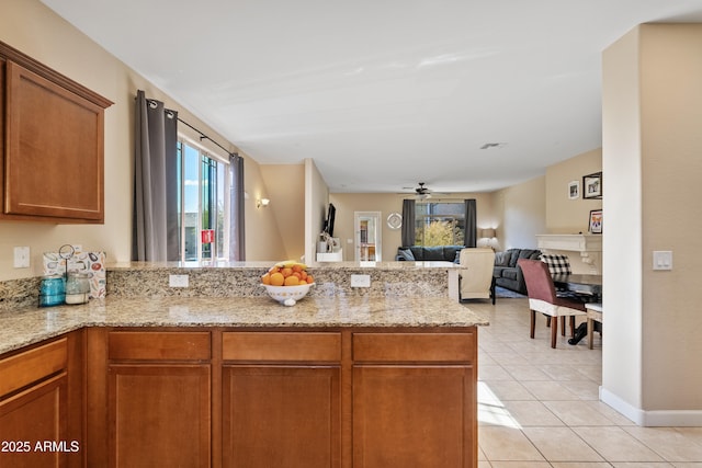 2150 W Alameda Rd Unit 1313, Phoenix, AZ 85085 - kitchen with a peninsula, light tile patterned floors, light stone countertops, and brown cabinets