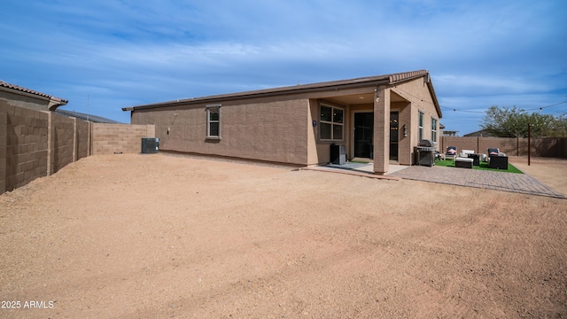 rear view of house with cooling unit and a patio