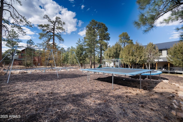 view of yard with playground community and a trampoline