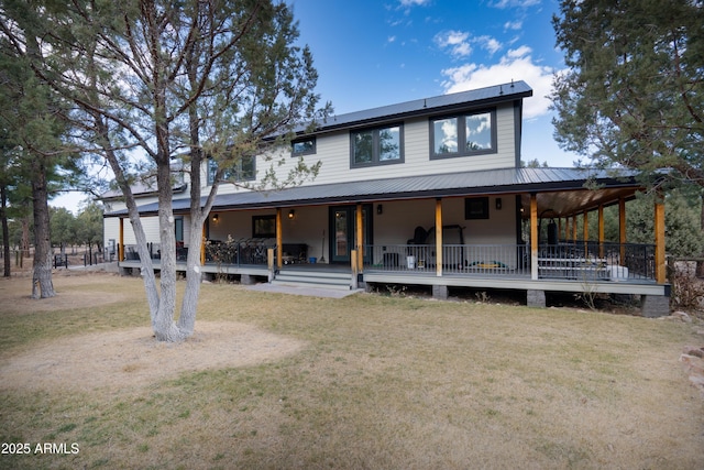 view of front of house featuring a porch, a front yard, and metal roof