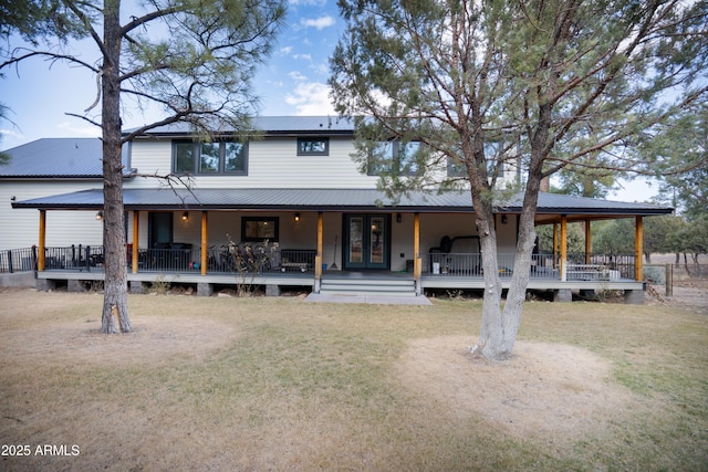 back of property featuring metal roof, french doors, a lawn, and a porch