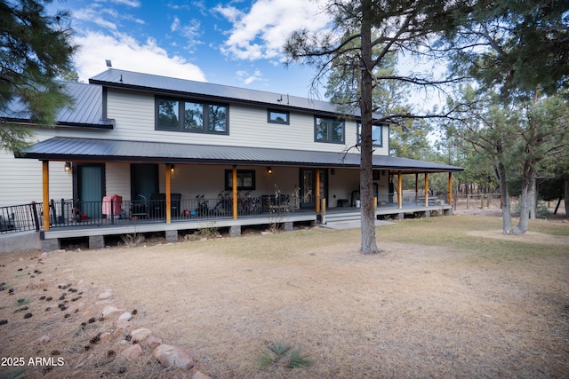 rear view of house with covered porch and metal roof