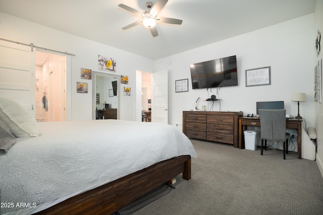 carpeted bedroom with ceiling fan and a barn door