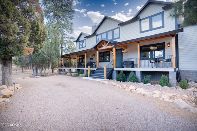 view of front of house featuring gravel driveway and a porch