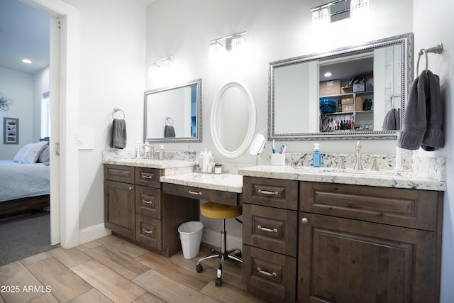 ensuite bathroom with baseboards, ensuite bath, vanity, and wood tiled floor