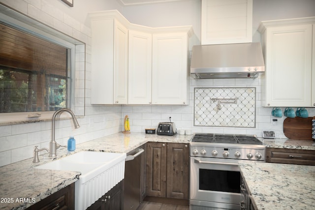 kitchen featuring appliances with stainless steel finishes, extractor fan, a sink, and white cabinetry