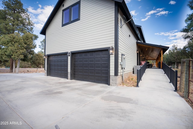 view of side of property with a garage, driveway, and cooling unit