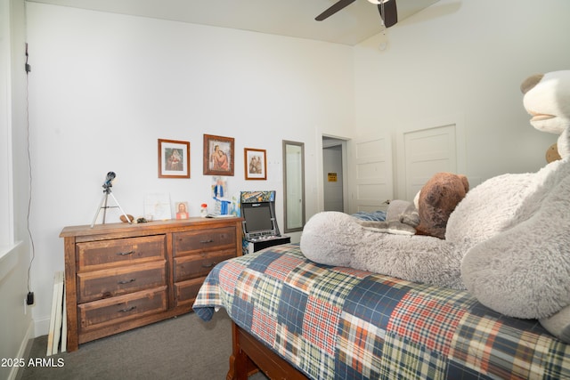 carpeted bedroom featuring ceiling fan, a high ceiling, and baseboards