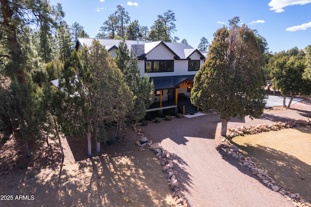 view of front of property featuring dirt driveway and metal roof