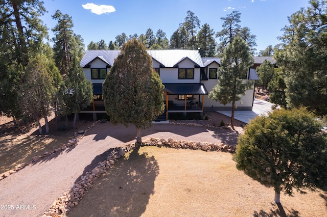 modern farmhouse with driveway and metal roof