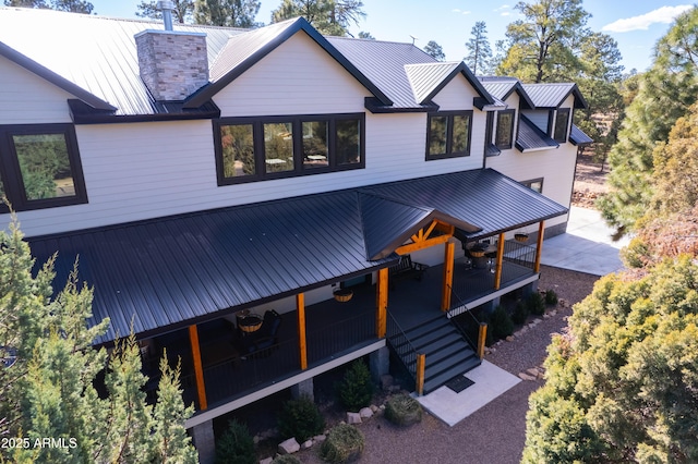 view of front of house with metal roof and a chimney