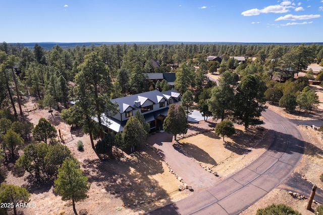 drone / aerial view with a wooded view