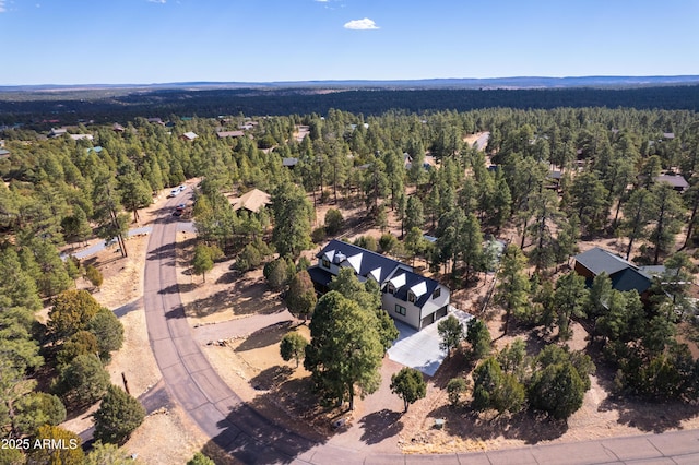 drone / aerial view with a wooded view