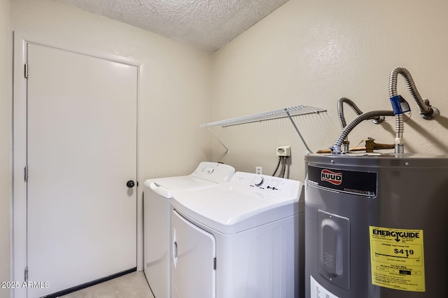 laundry room with laundry area, water heater, washer and clothes dryer, and a textured ceiling