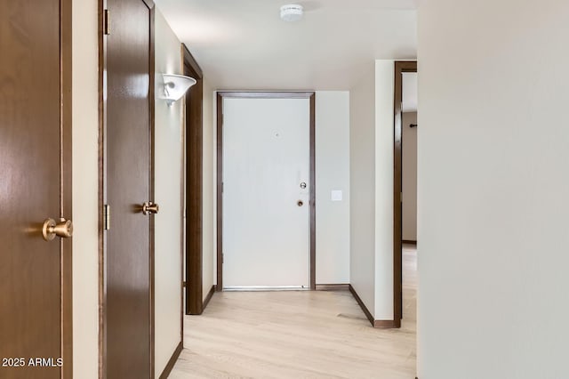 corridor featuring baseboards and light wood-style floors