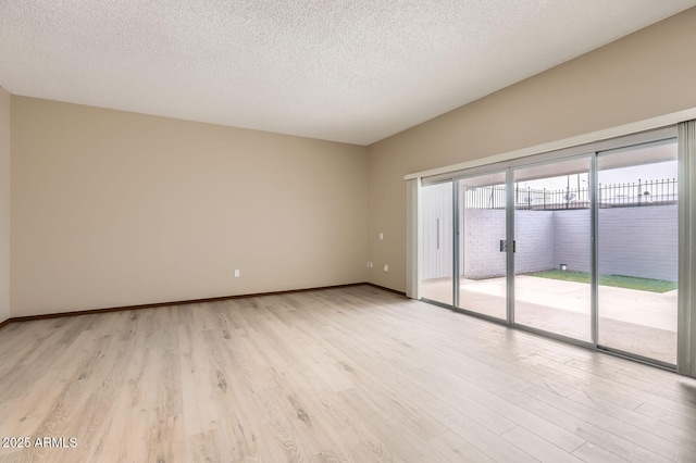 unfurnished room featuring light wood-style flooring, baseboards, and a textured ceiling