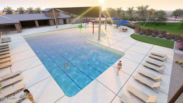 pool at dusk with a patio