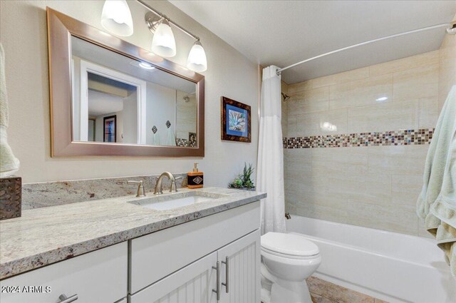 full bathroom with shower / bath combo, vanity, toilet, and tile patterned flooring